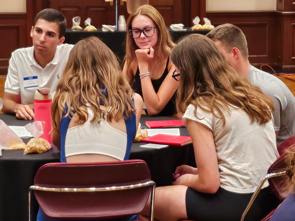 A group of students engaged in discussions around a round table