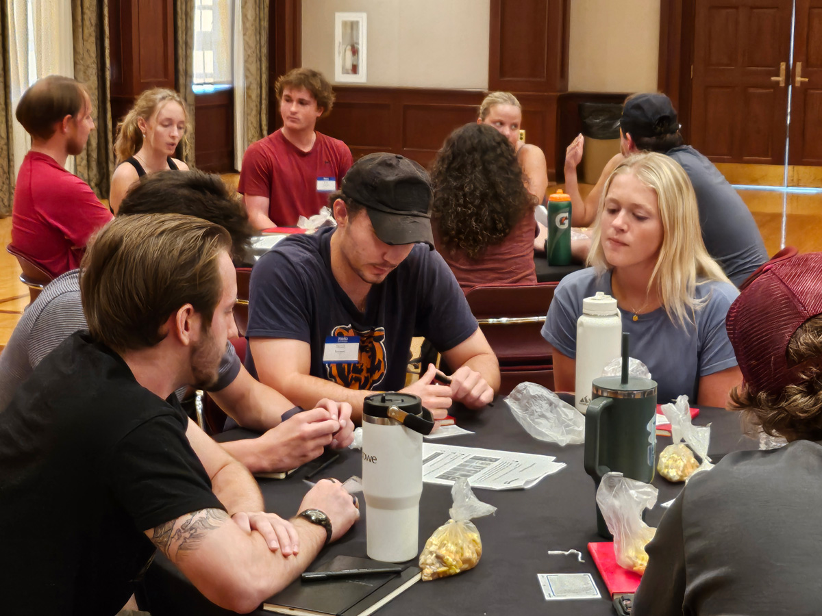 A group of students engaged in discussions around a round table