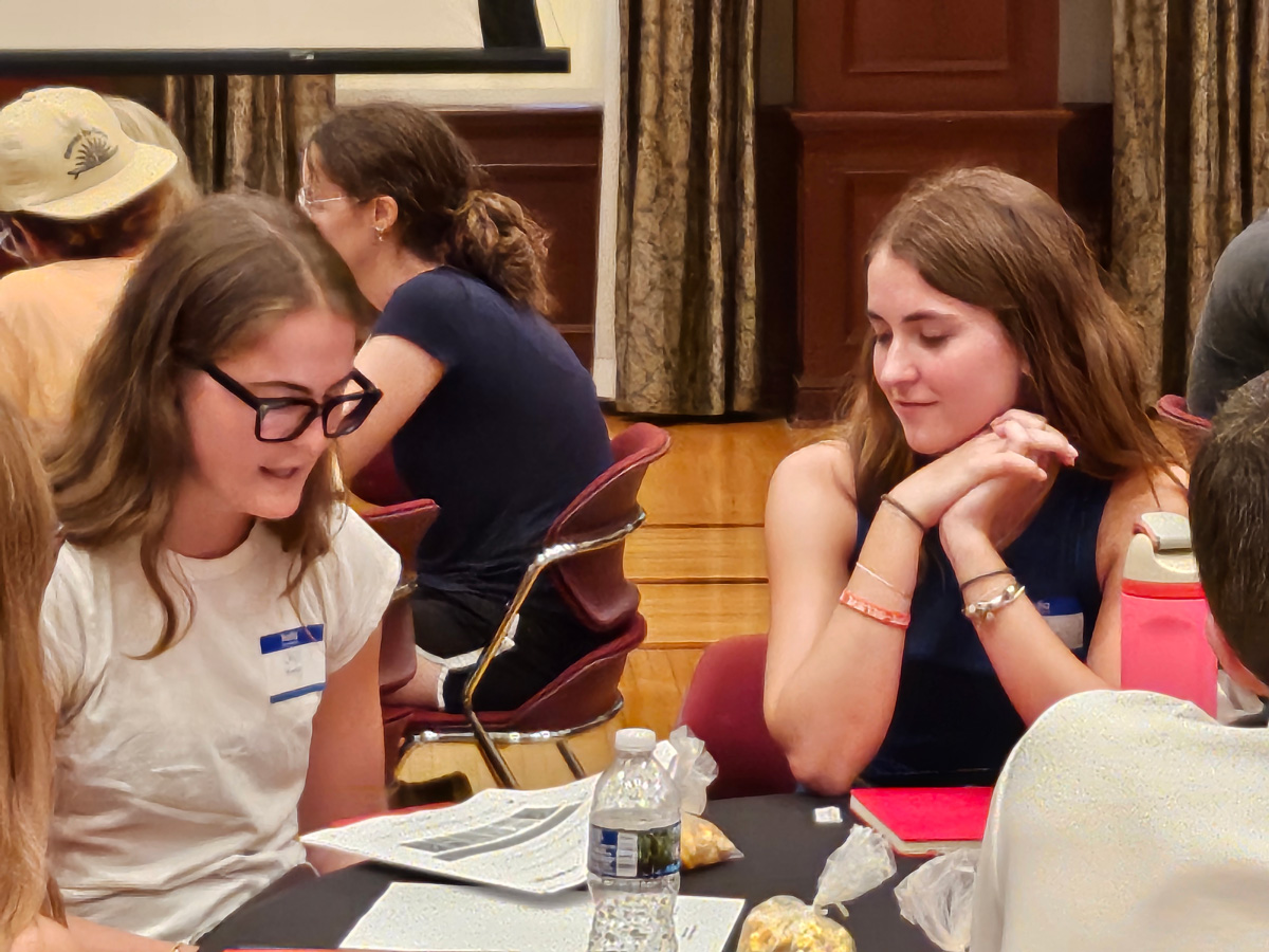 A group of students engaged in discussions around a round table