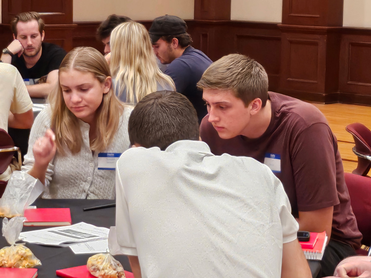 A group of students engaged in discussions around a round table