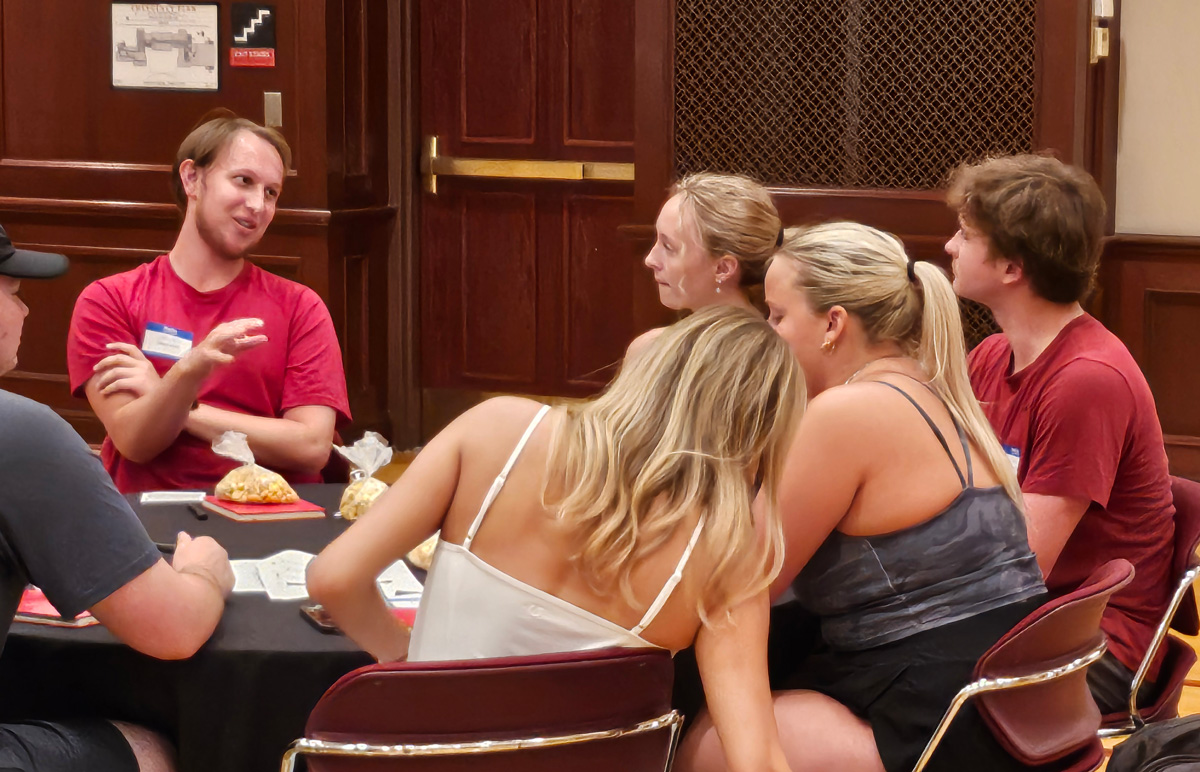 A group of students engaged in discussions around a round table