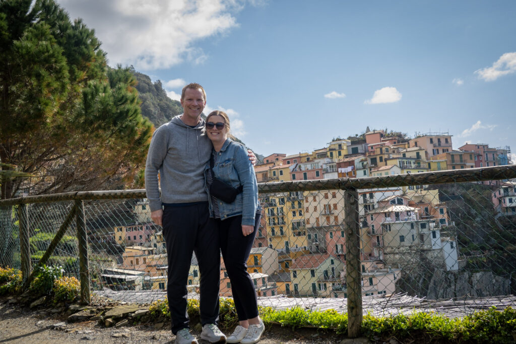 Photo of Dan and Kate in front of a scenic little town.