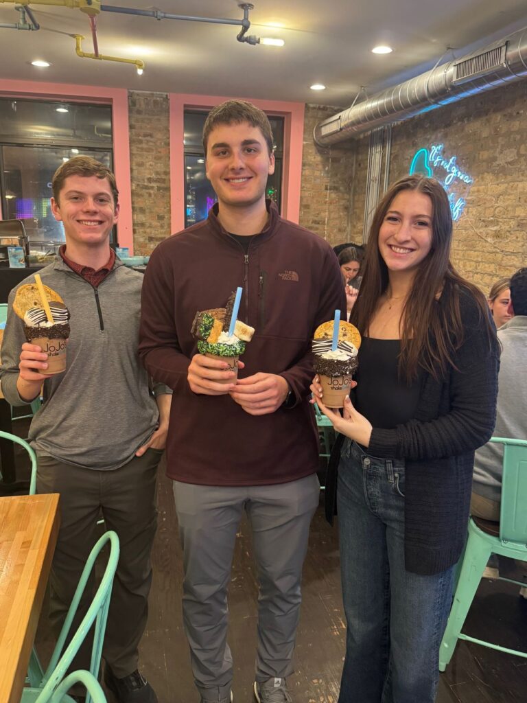 Three students holding milkshakes
