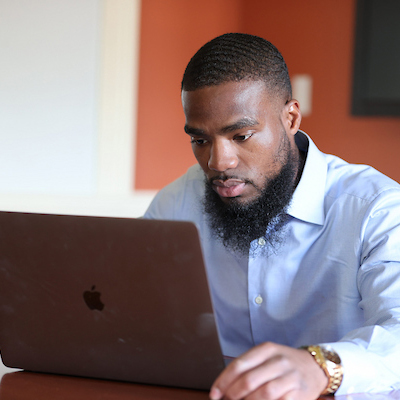 An online graduate student working on his computer