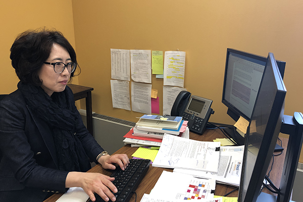 Yang Eun Chong sitting at her desk and doing work on her computer