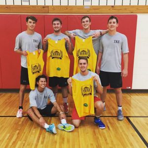 volleyball players holding up shirts