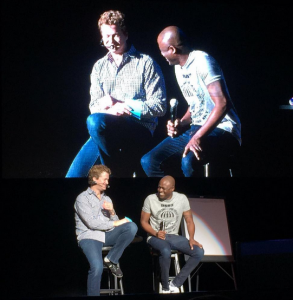 Wayne Brady and another person on stage laughing