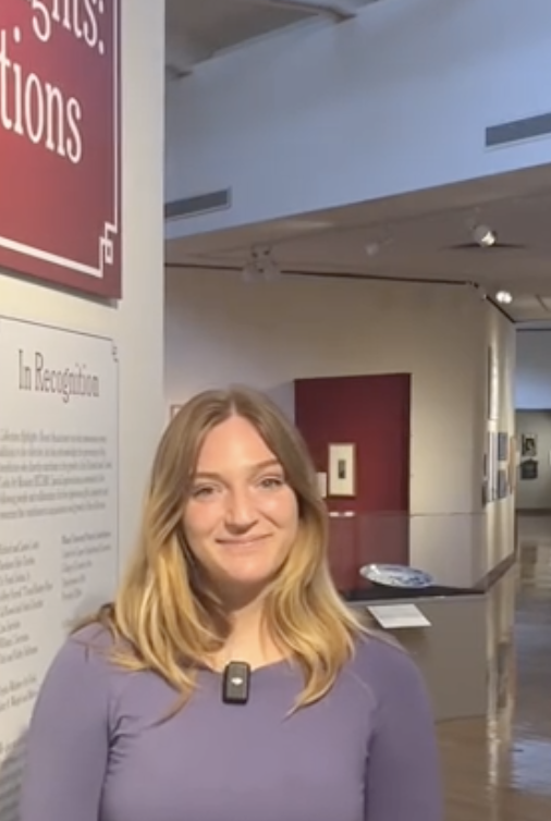 Photo of intern Alexis Mramor standing in front of the gallery entryway. 