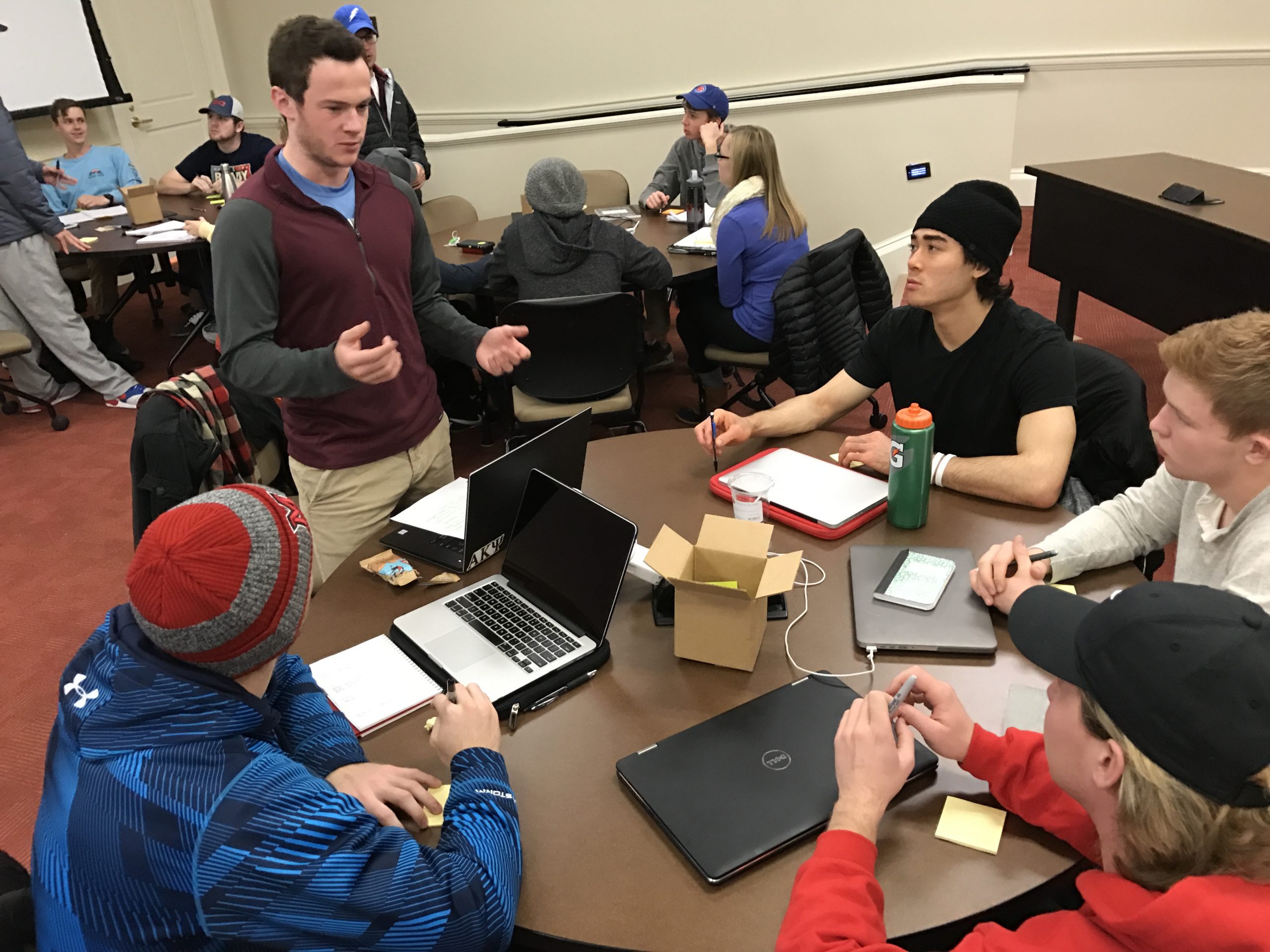 A photo shows a team of students in discussion around a table