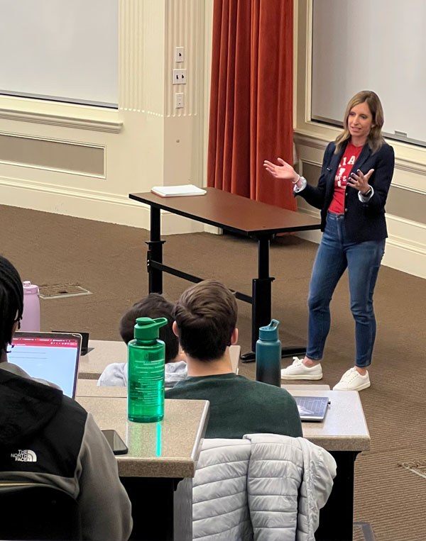 A female speaker speaks to a group of accountancy students in a classroom