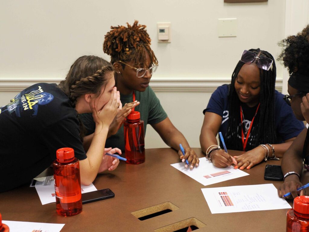 close-up of students collaborating while writing on a piece of paper