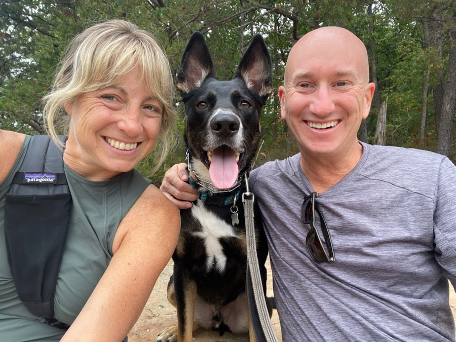 Photo of Kyle Bickhart and his wife Adrienne Keves with their dog Magnus sitting between them