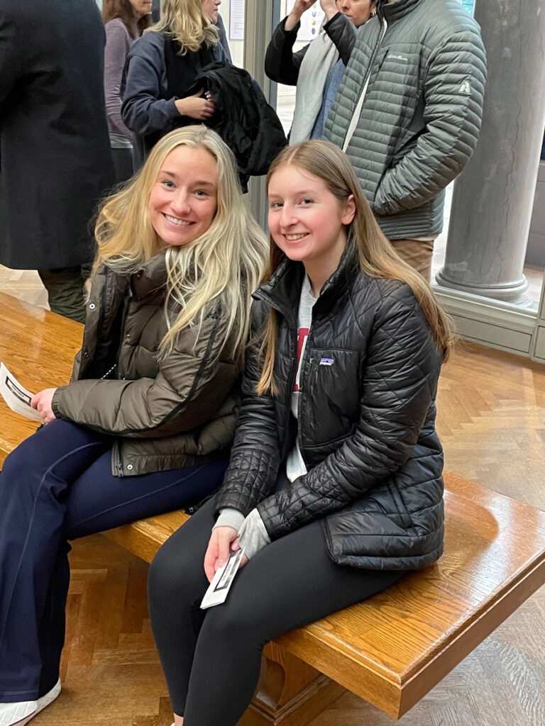 Two female students in a seated pose