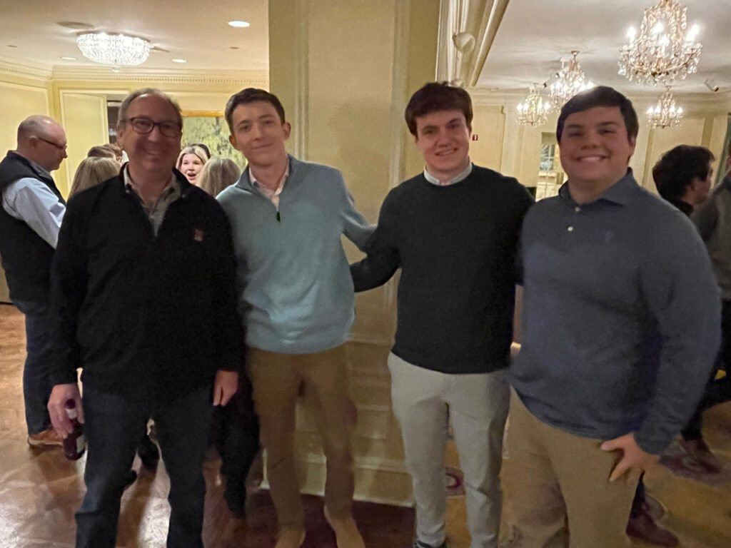 Students posing with a consultant during a celebratory dinner