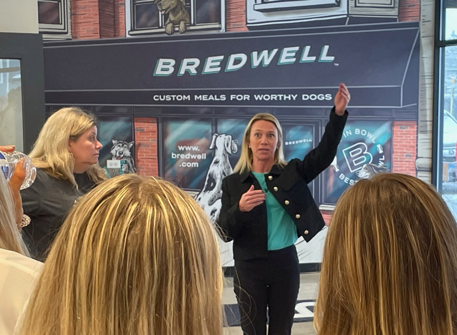 Two women stand in front of the Bredwell storefront speaking to a group of students