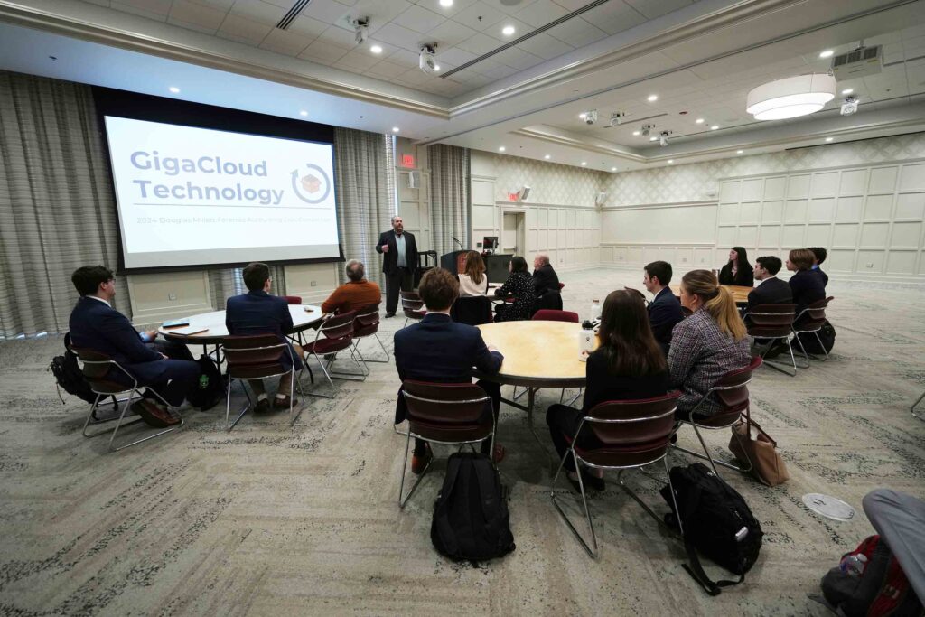 Photo of teams seated at round tables facing a slide projector screen with the title "GigaCloud Technology"