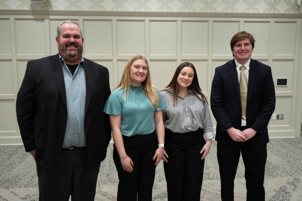 Photo of Professor Jon Grenier with team of three students