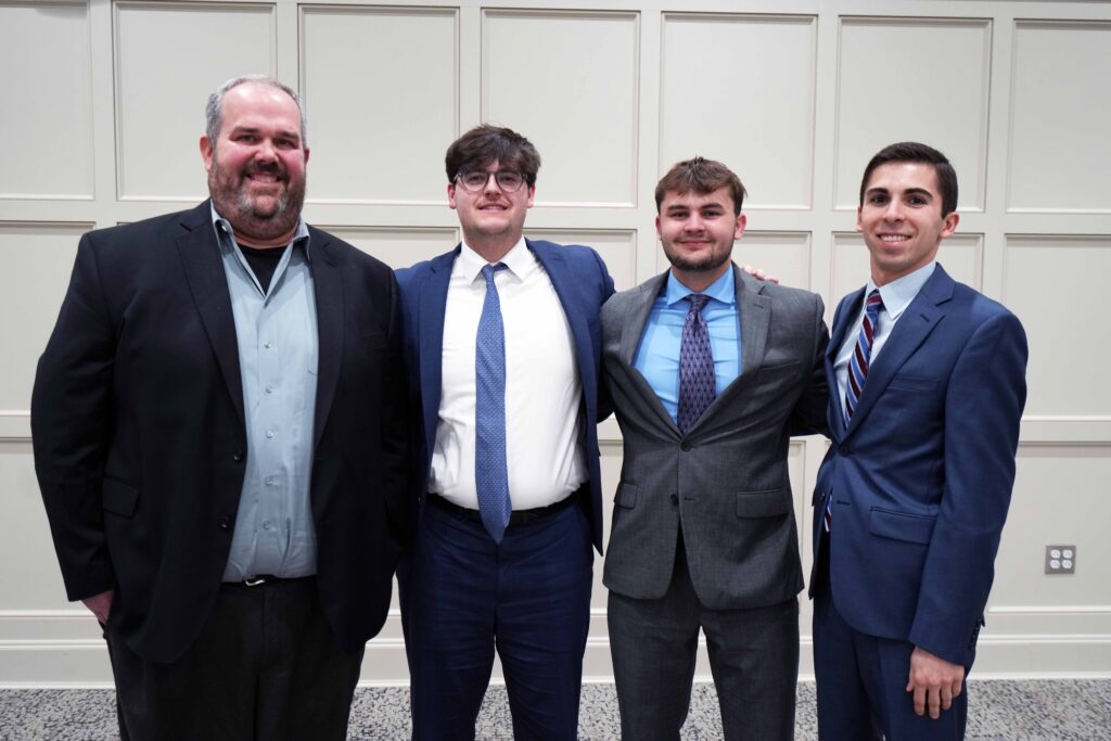 Photo of Professor Jon Grenier with team of three students