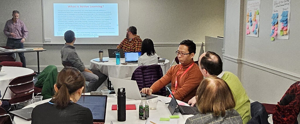 Photo of accountancy faculty seated at round tables during a workshop.