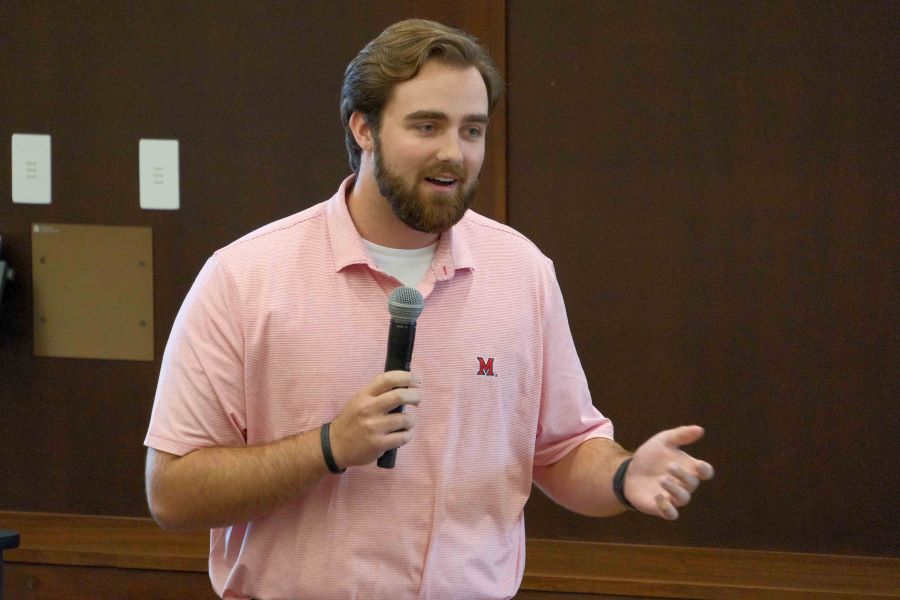 Photo of Nathan Schuster holding a microphone
