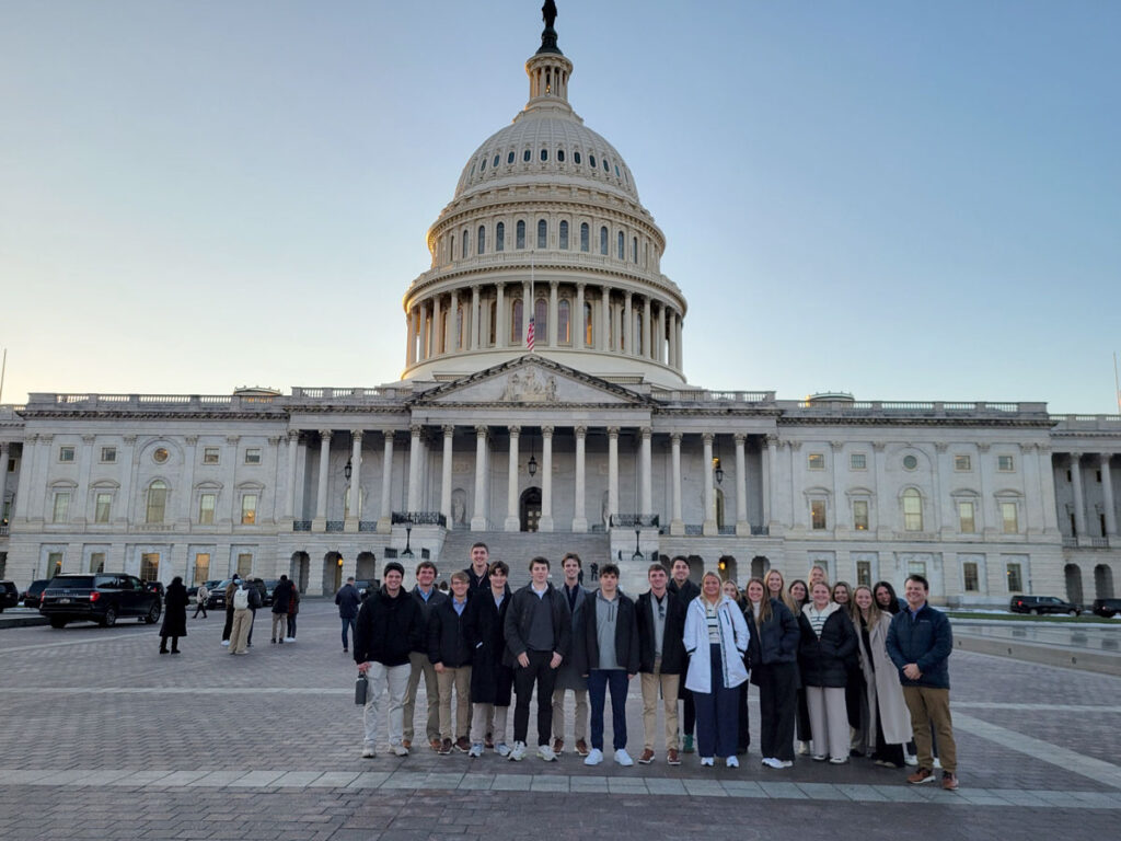 Student group posing in front of the U.S. capitol building.