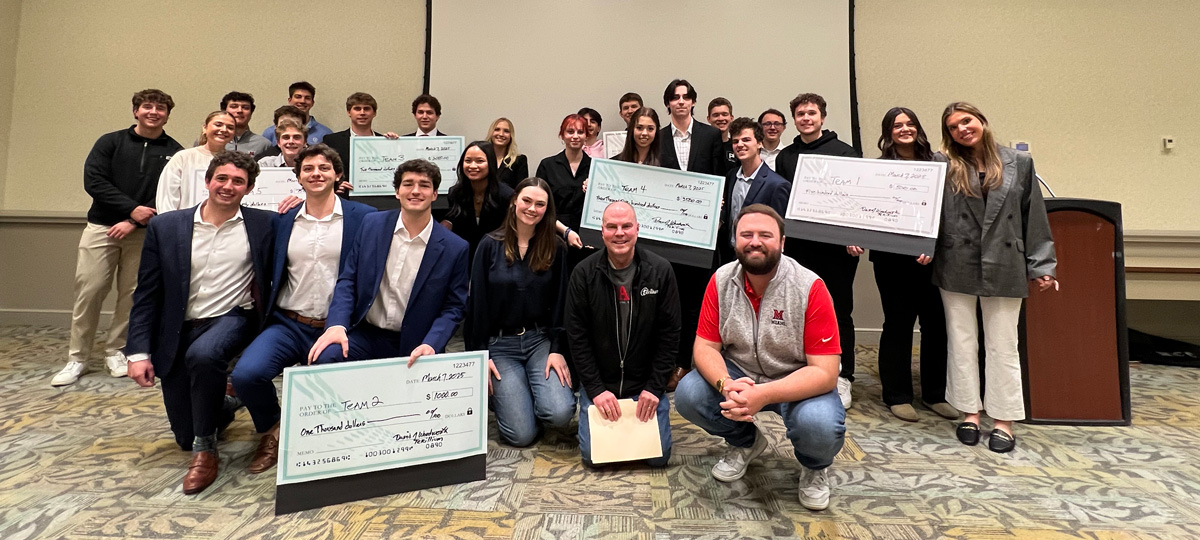 A group photo of the winning teams holding up giant checks