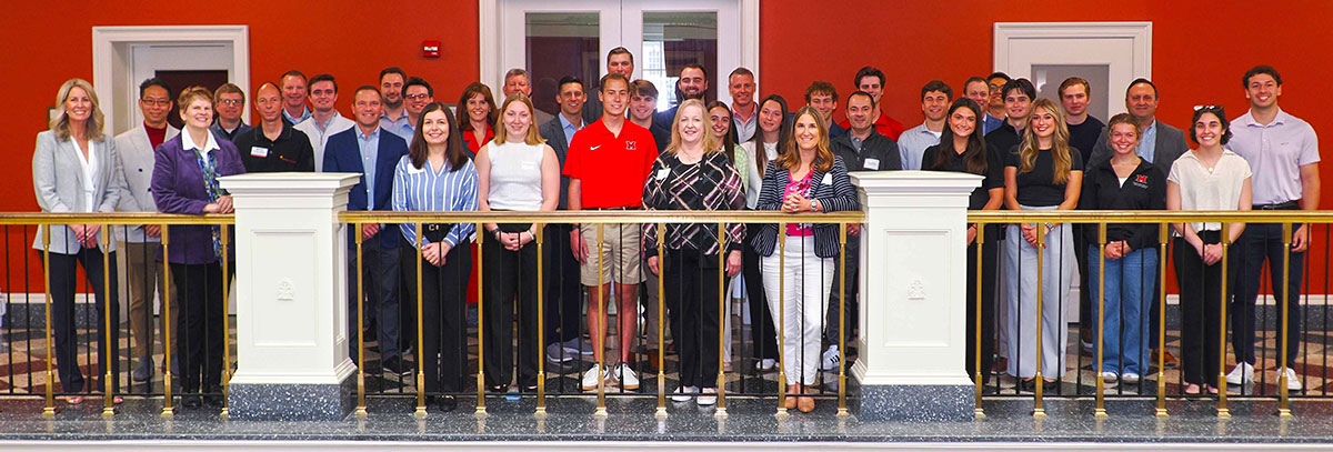 Group photo of 38 attendees consisting of faculty, AAG members, and students on the FSB balcony