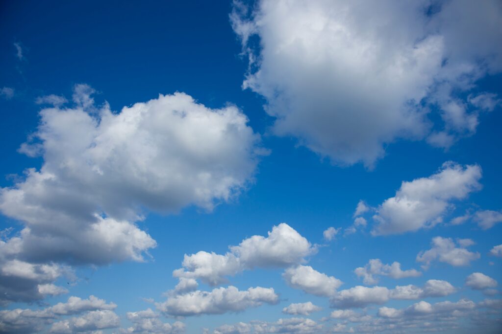 Cumulus clouds across a blue sky.