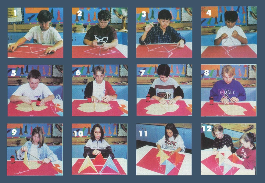 Students assembling a triangular frame from white plastic straws and white kite string on a red tabletop and using rubber cement to attach a white tissue paper panel to a straw tetrahedron frame.