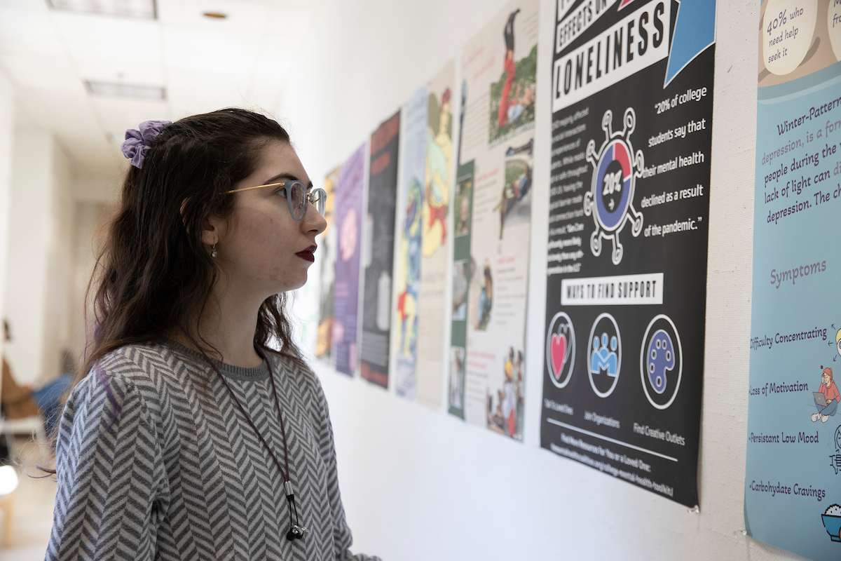 Miami student looking at some posters on a wall in Hiestand Hall