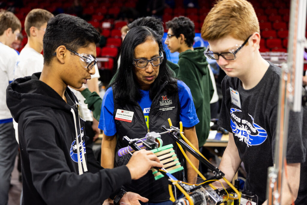 Dean of the College of Engineering and Computing, Beena Sukumaran, judging the entry of two students during a high school robotics competition.