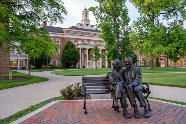 sculpture of the Farmers sitting on a bench outside of the Farmer School of Business
