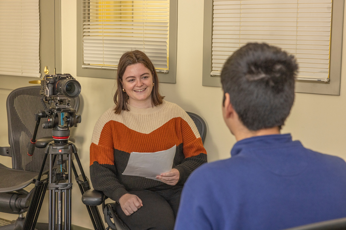 a member of the storytelling team interviewing a student