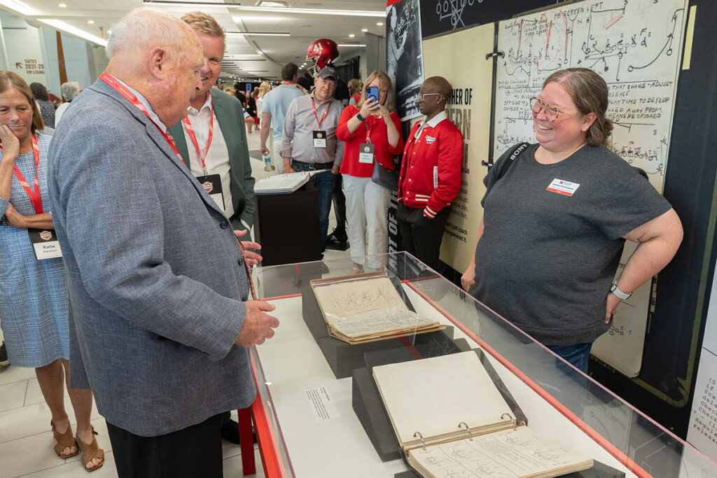 Coache Paul Brown views archival playbooks preserved by Miami University Libraries