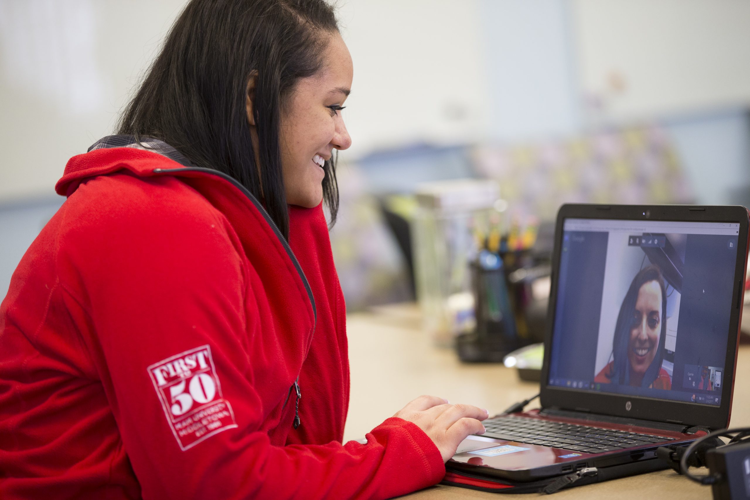 Woman smiles at woman during video chat on a laptop