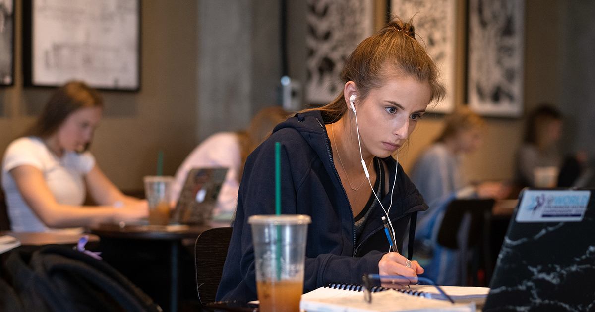 A woman working on her online course in a coffee shop