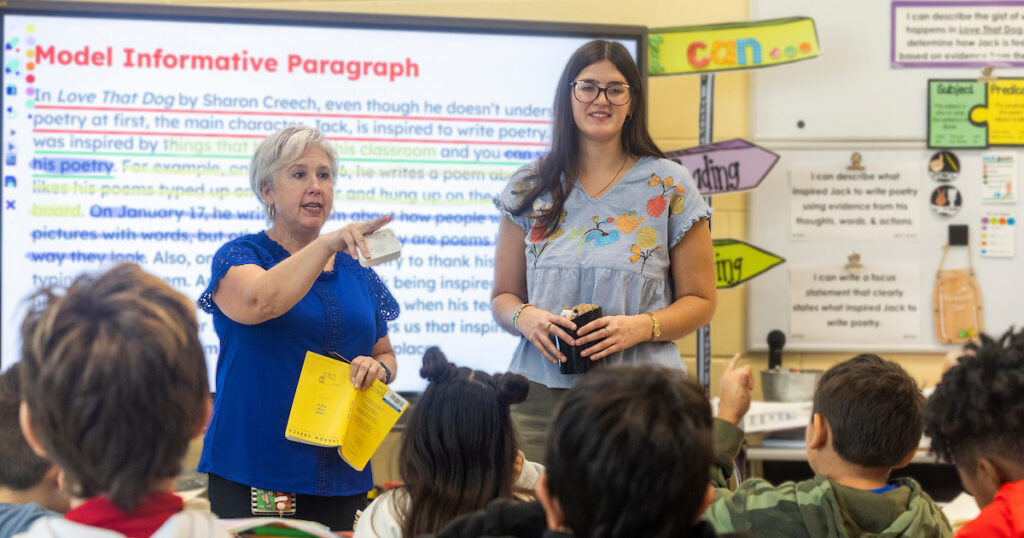 Teachers helping elementary students with reading and comprehension.