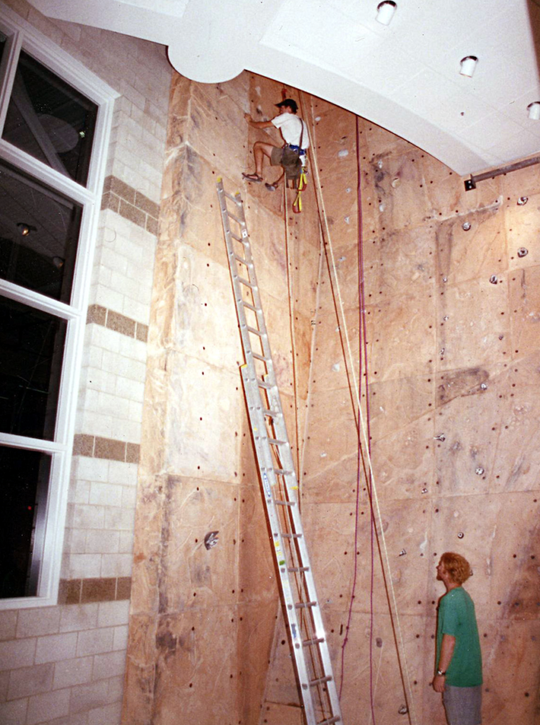 Tim Steele climbs high on the newly installed wall at Miami’s Rec Center in 1994 while James O'Loughlin, another OPC alum, looks on. Steele says, “This was among the first routes ever set on that wall. At this point, the climbing wall build had been completed and we were getting ready to open the facility. This photo would have been very close to the opening date of the Rec Center.” (Photo courtesy of Tim Steele)