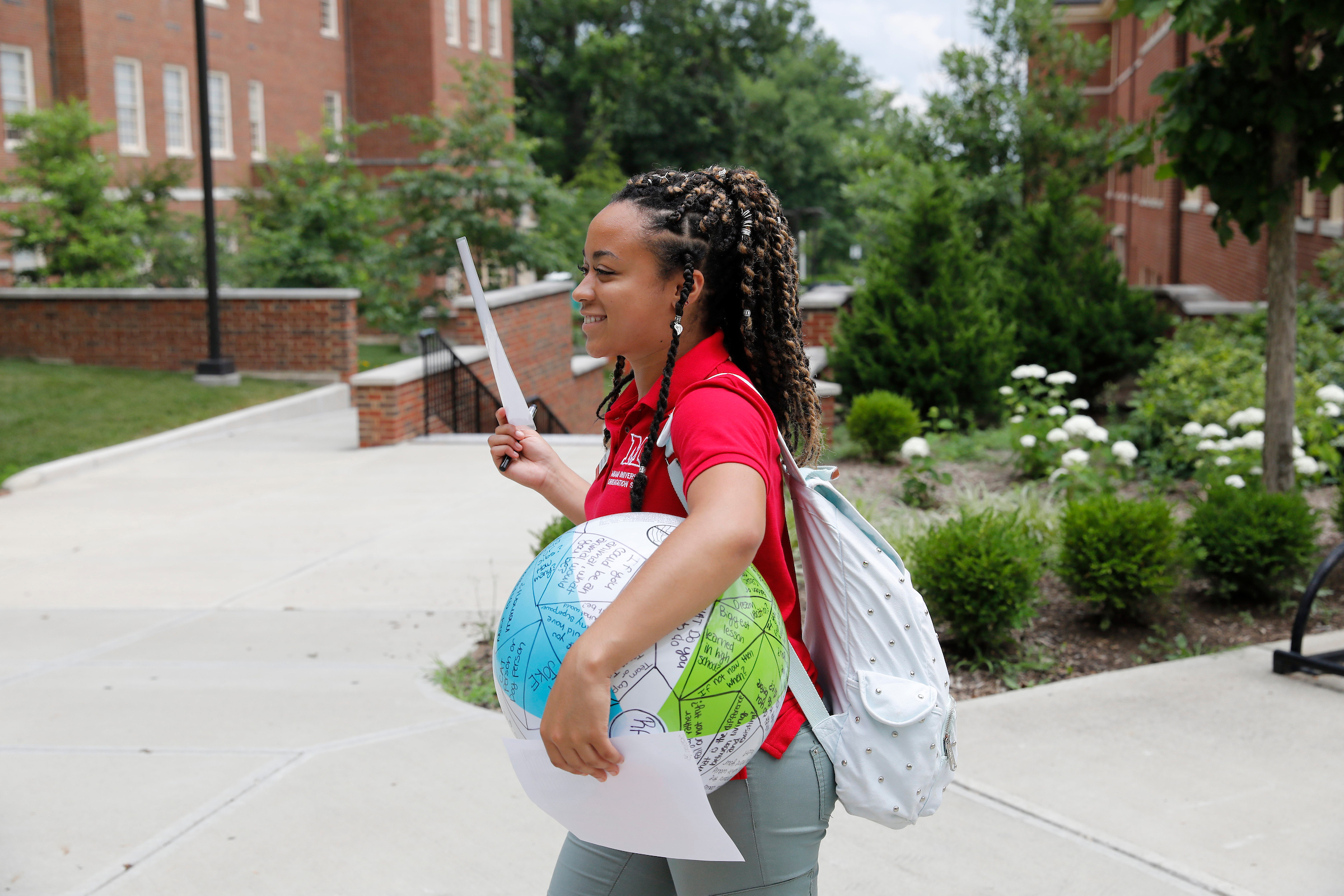 SOUL leader in a red polo carrying a beach ball.