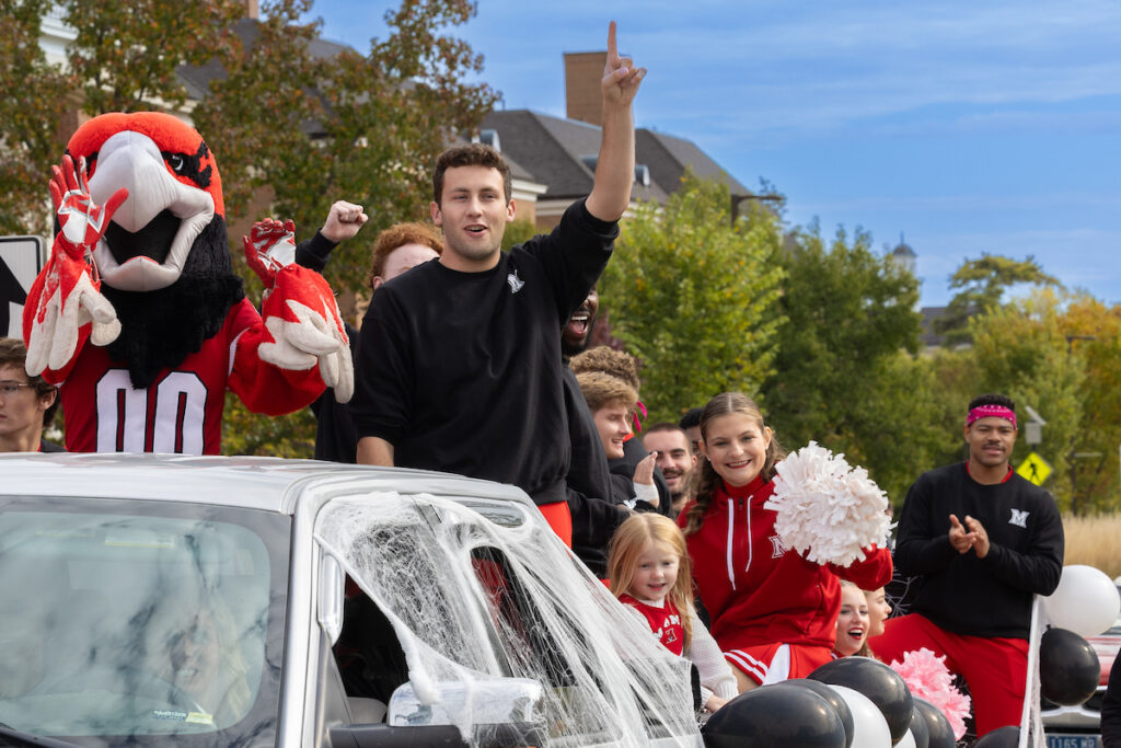 Students sitting in a car with swoop for the homecoming parade