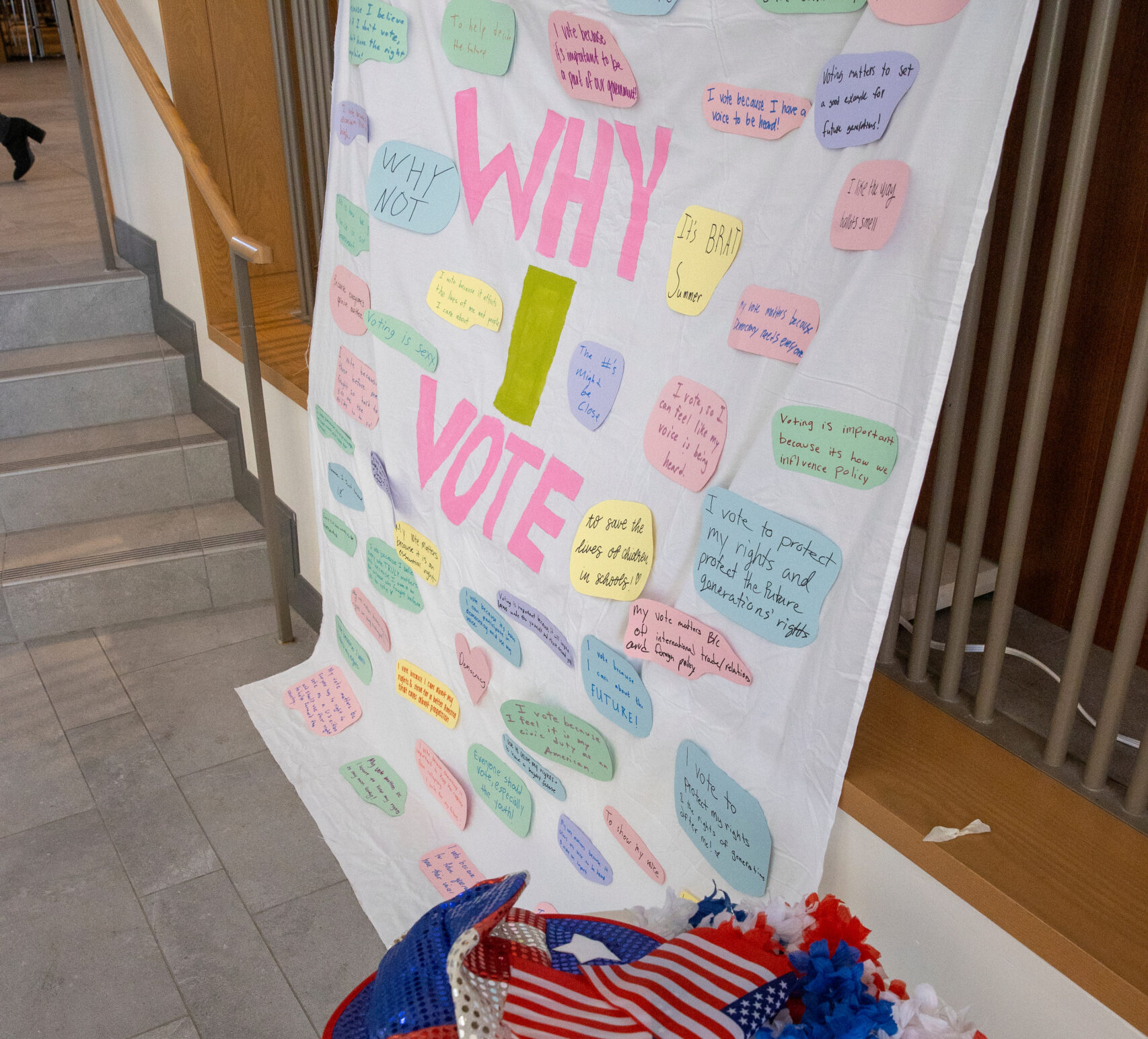Large white poster with the words "Why I vote" in the center and dozens additional paper attached with reasons people vote.