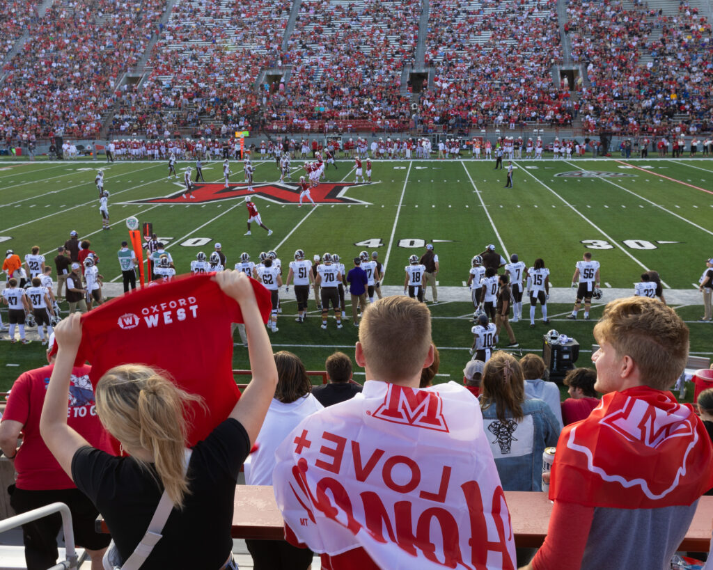 A family showing their Miami merch during a football game