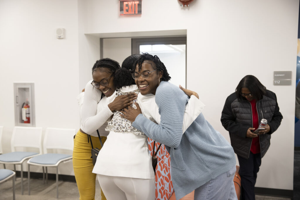 Three women hugging each other happily