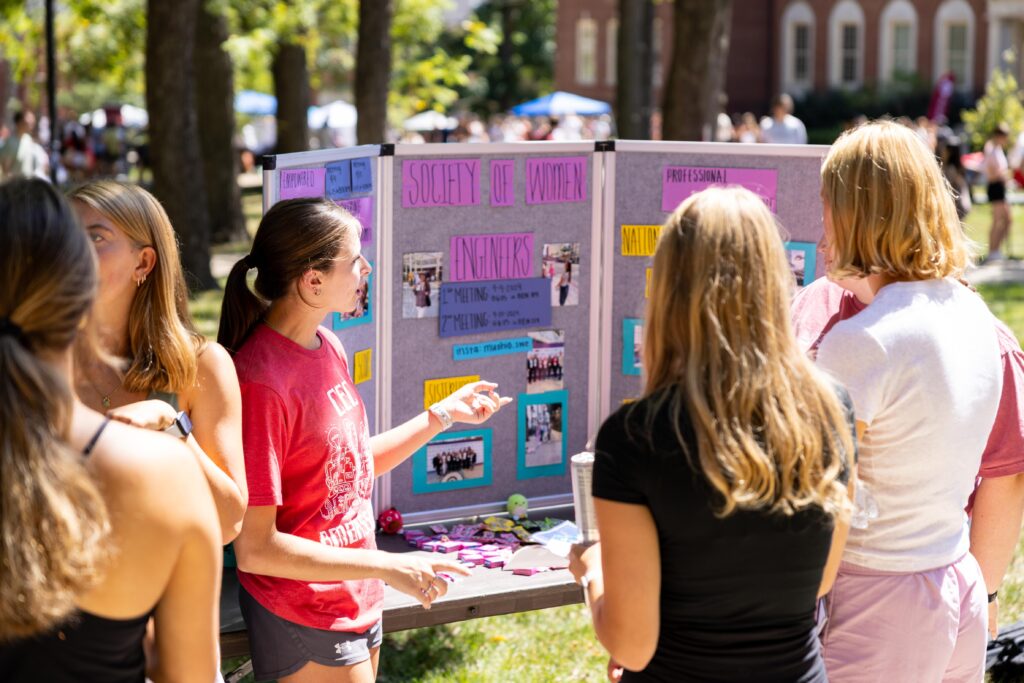 A student introducing her organization to others at Mega Fair