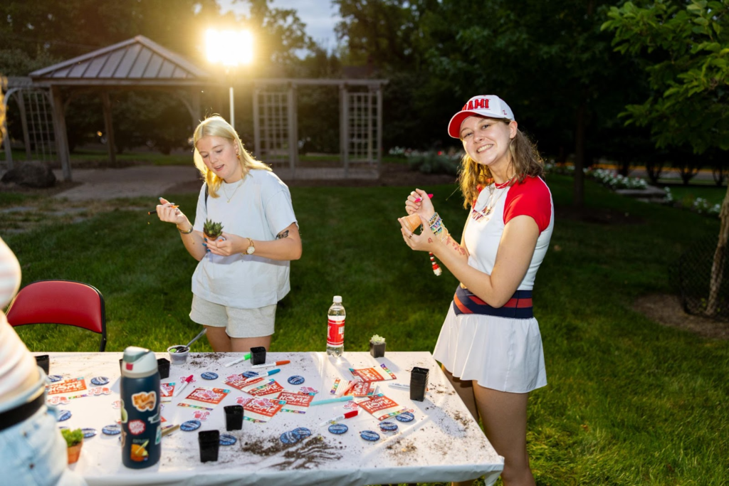 A student outside making a plant at an event. 