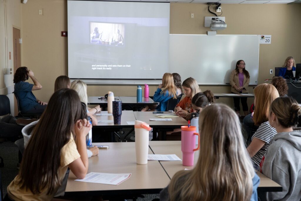 A classroom of students watching a film. 