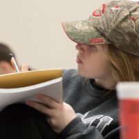 A student writing on their notebook