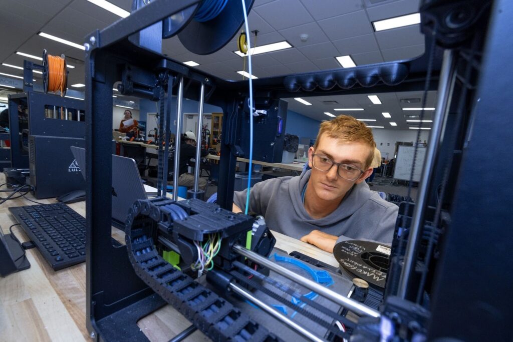A student looking at the 3D printer